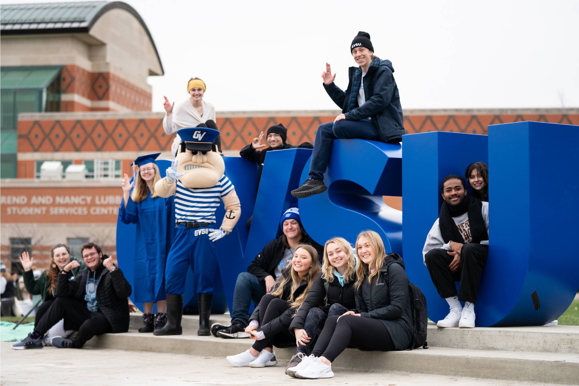 students posing in front of GVSU large letters on campus